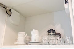 Tea set and kettle on the shelf in the kitchen cupboard royalty free stock photography Tea set and kettle on the shelf in the kitchen cupboard royalty free stock photography