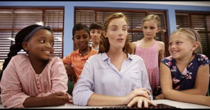 Teacher assisting school kids on personal computer in classroom stock video Teacher assisting school kids on personal computer in classroom stock video