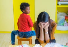 Teacher get headache with two naughty kids in classroom at kindergarten school stock photography Teacher get headache with two naughty kids in classroom at kindergarten school stock photography
