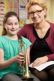 Teacher Helping Pupil To Play Trumpet In Music Lesson stock images Teacher Helping Pupil To Play Trumpet In Music Lesson stock images
