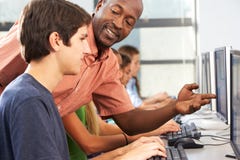 Teacher Helping Students Working At Computers In Classroom royalty free stock images Teacher Helping Students Working At Computers In Classroom royalty free stock images