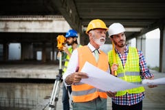 Team of architects and engineer in group on construciton site check documents and business workflow stock photo Team of architects and engineer in group on construciton site check documents and business workflow stock photo