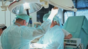 Team of doctors in sterile clothing and mask during surgery. Slow motion