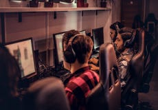 Team van tienergamersspelen in een multiplayervideospelletje op PC in een gokkenclub royalty-vrije stock fotografie Team van tienergamersspelen in een multiplayervideospelletje op PC in een gokkenclub royalty-vrije stock fotografie