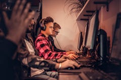 Team van tienergamersspelen in een multiplayervideospelletje op PC in een gokkenclub stock fotografie Team van tienergamersspelen in een multiplayervideospelletje op PC in een gokkenclub stock fotografie