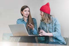 Teamwork, zwei junge Geschäftsfrauen, die bei Tisch im Café sitzen, trinkender Kaffee und Unterhaltung stockbild Teamwork, zwei junge Geschäftsfrauen, die bei Tisch im Café sitzen, trinkender Kaffee und Unterhaltung stockbild