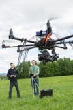 Technici die UAV Spionhommel vliegen royalty-vrije stock afbeeldingen Technici die UAV Spionhommel vliegen royalty-vrije stock afbeeldingen