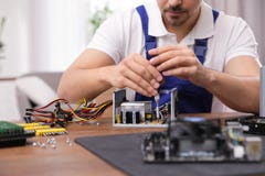 Technicien masculin r?parant l'unit? d'alimentation d'?nergie ? la table ? l'int?rieur photos stock Technicien masculin r?parant l'unit? d'alimentation d'?nergie ? la table ? l'int?rieur photos stock
