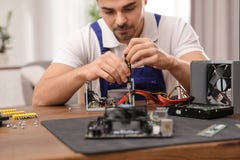 Technicien masculin r?parant l'unit? d'alimentation d'?nergie ? la table photo stock Technicien masculin r?parant l'unit? d'alimentation d'?nergie ? la table photo stock