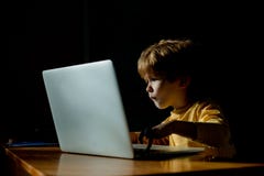 Technology. Computer user. The child looks with passion at the computer screen. Monitor, interest information for royalty free stock image Technology. Computer user. The child looks with passion at the computer screen. Monitor, interest information for royalty free stock image