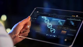 Hand with virtual dna projection on tablet screen