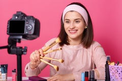 Tecnologia e conceito publicando em blogs, modernos dos povos O blogger video de sorriso feliz da beleza da mulher guarda escovas imagem de stock Tecnologia e conceito publicando em blogs, modernos dos povos O blogger video de sorriso feliz da beleza da mulher guarda escovas imagem de stock