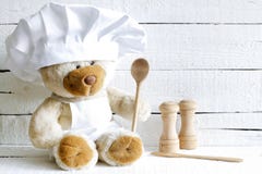 Teddybeer in chef-kokhoed met achtergrond van het lepel de abstracte voedsel Stock Foto Teddybeer in chef-kokhoed met achtergrond van het lepel de abstracte voedsel Stock Foto