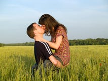 Teen Couple Kissing In Field Royalty Free Stock Photography