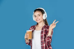 teen girl in headphones with coffee showing peace sign stock photo teen girl in headphones with coffee showing peace sign stock photo