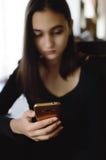 Teen girl hold using mobile phone or reading news from smartphone. The girl`s face is blurry stock image Teen girl hold using mobile phone or reading news from smartphone. The girl`s face is blurry stock image