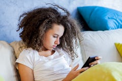 Teen Girl Resting And Usiing Digital Tablet On Sofa At Home Stock Images