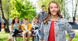 Smiling teenage girl in denim jacket over friends royalty free stock images Smiling teenage girl in denim jacket over friends royalty free stock images