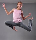 Teenage girl skipping and dancing in studio. Child exercising with jumping on grey background. royalty free stock photos Teenage girl skipping and dancing in studio. Child exercising with jumping on grey background. royalty free stock photos
