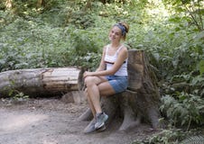 Teenage girl smiling happily sitting along a trail, Snoqualmie Park, State of Washington royalty free stock photography Teenage girl smiling happily sitting along a trail, Snoqualmie Park, State of Washington royalty free stock photography
