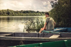 Teenager boy lonely contemplation countryside landscape on river bank during countryside summer holidays royalty free stock photography Teenager boy lonely contemplation countryside landscape on river bank during countryside summer holidays royalty free stock photography