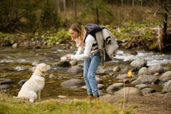 Young girl trains and plays with puppy golden retriever in the wild, next to a river. royalty free stock photography Young girl trains and plays with puppy golden retriever in the wild, next to a river. royalty free stock photography