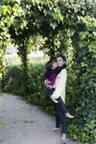 Teenager picking up his little sister in the garden of a house. stock photos Teenager picking up his little sister in the garden of a house. stock photos
