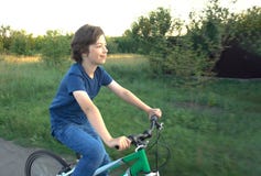 Teenager riding a bicycle on the road summer sunlit royalty free stock photos Teenager riding a bicycle on the road summer sunlit royalty free stock photos