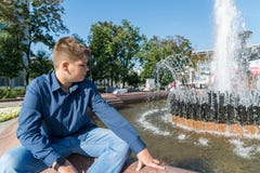 Teenager of 14 years is sitting near fountain royalty free stock image Teenager of 14 years is sitting near fountain royalty free stock image