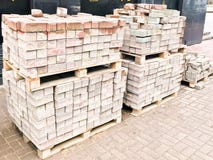 Tegel van het straatsteen de rode cement voor het leggen van wegenbouw, bestrating op houten pallets bij een bouwwerf royalty-vrije stock foto Tegel van het straatsteen de rode cement voor het leggen van wegenbouw, bestrating op houten pallets bij een bouwwerf royalty-vrije stock foto