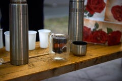 Tekanna med te, thermoses och plast- exponeringsglas arkivbilder Tekanna med te, thermoses och plast- exponeringsglas arkivbilder