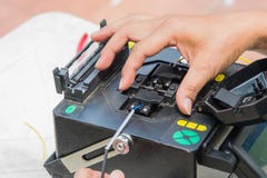 Tekniker som klipper, och optiska kablar för fusionfiber royaltyfri bild Tekniker som klipper, och optiska kablar för fusionfiber royaltyfri bild