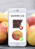 Telefon mit der Einkaufsliste gesund gegen ungesunde chocolat Apfeldiät stockbild Telefon mit der Einkaufsliste gesund gegen ungesunde chocolat Apfeldiät stockbild