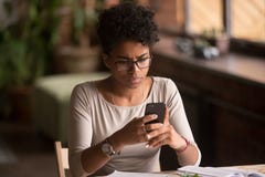 Telefone celular africano confuso virado da terra arrendada da mulher que tem o problema com telefone fotografia de stock Telefone celular africano confuso virado da terra arrendada da mulher que tem o problema com telefone fotografia de stock