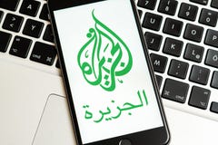 Telefone preto com logotipo dos meios noticiosos Al Jazeera na tela imagem de stock Telefone preto com logotipo dos meios noticiosos Al Jazeera na tela imagem de stock