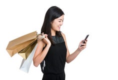 Telefono cellulare asiatico di uso della giovane donna con il sacchetto della spesa fotografie stock Telefono cellulare asiatico di uso della giovane donna con il sacchetto della spesa fotografie stock