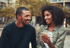 Telefono cellulare della tenuta dell'amica a disposizione che esamina il suo ragazzo immagine stock libera da diritti Telefono cellulare della tenuta dell'amica a disposizione che esamina il suo ragazzo immagine stock libera da diritti