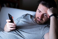 Telefono cellulare maschio della tenuta del ritratto di tristezza da solo immagini stock Telefono cellulare maschio della tenuta del ritratto di tristezza da solo immagini stock