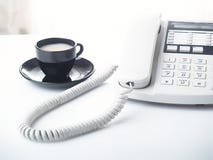 Telefono e tazza dell'ufficio immagine stock Telefono e tazza dell'ufficio immagine stock