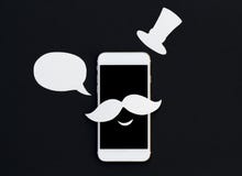 Teléfono blanco con la burbuja y la sonrisa del texto de la historieta Smartphone en bigote y sombrero del vintage Fotos de archivo