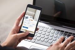 Teléfono de Person Booking Hotels Using Cell foto de archivo libre de regalías Teléfono de Person Booking Hotels Using Cell foto de archivo libre de regalías