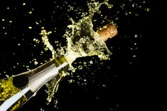 Tema da celebração com explosão de espirrar o vinho espumante do champanhe no fundo preto Tema da celebração com explosão de espirrar o vinho espumante do champanhe no fundo preto