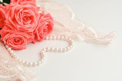 Tema feminino delicado As rosas corais cor-de-rosa tendem a cor em um pálido - colar cor-de-rosa do sutiã e da pérola em um fundo foto de stock Tema feminino delicado As rosas corais cor-de-rosa tendem a cor em um pálido - colar cor-de-rosa do sutiã e da pérola em um fundo foto de stock