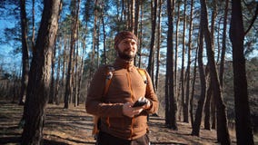 Tematurism och teknologi Ung caucasian man med sk?gget och ryggs?cken N?r du fotvandrar turisten i pinjeskog anv?nder teknologi, royaltyfri bild Tematurism och teknologi Ung caucasian man med sk?gget och ryggs?cken N?r du fotvandrar turisten i pinjeskog anv?nder teknologi, royaltyfri bild