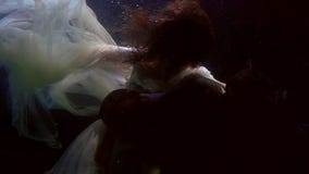 Tender woman and man are hugging underwater, slow motion of caress of lovers