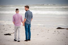 Tenersi per mano di camminata delle coppie gay fotografia stock Tenersi per mano di camminata delle coppie gay fotografia stock