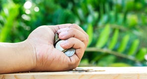 Tenir beaucoup de pièces de monnaie dans la main sur le plancher Épargnez l'argent et l'employez Photos stock Tenir beaucoup de pièces de monnaie dans la main sur le plancher Épargnez l'argent et l'employez Photos stock