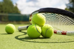 Tennisbollar och racket på gräsdomstolen Royaltyfri Foto Tennisbollar och racket på gräsdomstolen Royaltyfri Foto