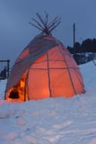 Tente rougeoyante de tipi dans la neige photo stock Tente rougeoyante de tipi dans la neige photo stock
