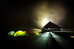 Tentes de camping lumineuses la nuit dans la zone d'alpin Photographie stock Tentes de camping lumineuses la nuit dans la zone d'alpin Photographie stock
